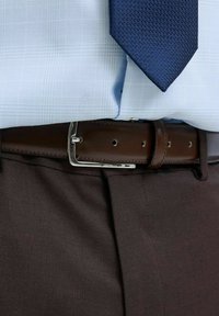 Bruine leren riem met een zilveren gesp, gedragen over donkere bruine broeken, gecombineerd met een lichtblauw geruit shirt en een gestructureerde marineblauwe stropdas.