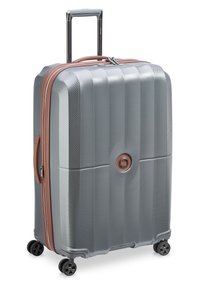 Valigia rigida grigia con superficie testurizzata, zip e dettagli bronzo, manico estensibile e quattro ruote nere per la mobilità.