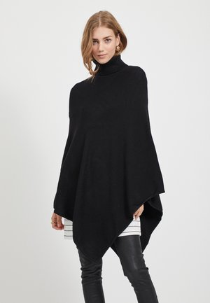 Svart turtleneck poncho tillverkad av mjukt, stickat tyg, med en draperad siluett, spetsig nederkant och vida ärmhål.