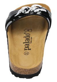 Sandale à glisser noire en vernis avec un accent en chaîne argentée, semelle en liège et semelle intérieure en beige texturé. Marquée "palado" et "Fabriqué en Espagne."