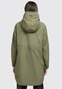 Olivgrön vattentät jacka med huva, långa ärmar, åtsittande midja och en triangel-logotypdetalj nära nederkanten. Slät textur.