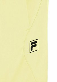 Tela de color amarillo claro con un logotipo "F" estilizado en negro dentro de un cuadrado cerca de una costura curva en el lado derecho.