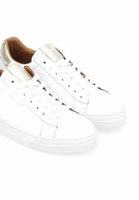 Witte leren sneakers met gouden accenten, ronde neus, platte zool en witte veters. Gladde textuur met een minimalistisch ontwerp.