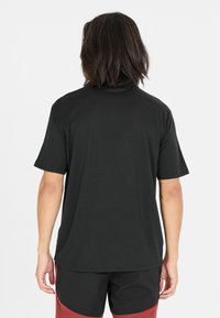 Svart kortärmad t-shirt i mjukt tyg med avslappnad passform, som har rund halsringning och slät yta.