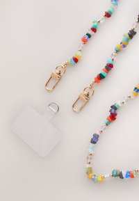 Lanière colorée en perles avec ferrures dorées et porte-badge transparent. Comprend des perles de différentes formes et tailles aux couleurs vives.