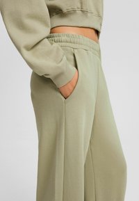 Ljust gröna bomullsblandning joggers med elastisk midja, sidoficka och ribbad mudd. Slät textur och avslappnad passform.