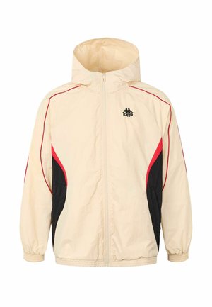 Kremasti hooded jakna s crvenim i crnim detaljima, s patentnim zatvaračem sprijeda, elastičnim rukavima i bočnim panelima za sportski dizajn. Prikazan logo Kappa.