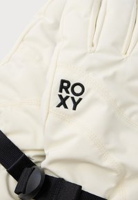 Valge isoleeritud kindel musta aktsentõmblusega ja "ROXY" logoga, millel on must reguleeritav rihm ja sile tekstuur.