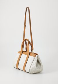 Sac fourre-tout avec un corps en toile blanche à motifs et des poignées en cuir brun. Dispose d'une base structurée, de deux poignées et d'une sangle longue réglable.