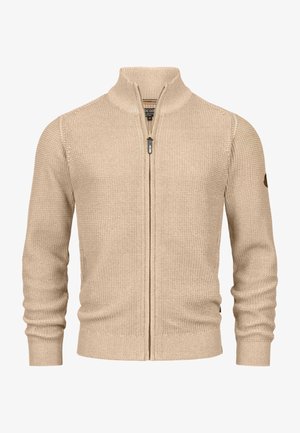 Beige vetoketjullinen villatakki, jossa on teksturoidun neulemateriaalin pinta, korkea kaulus sekä ribbaat huput ja helma. Vasemmassa hihassa on pieni logopatch.