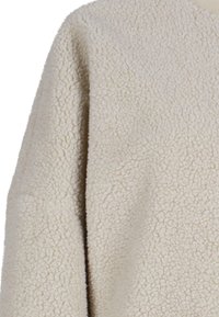 Beige Fleece-Stoff mit einer strukturierten, flauschigen Oberfläche. Verfügt über eine lockere Silhouette und ein Bootsausschnitt-Design.