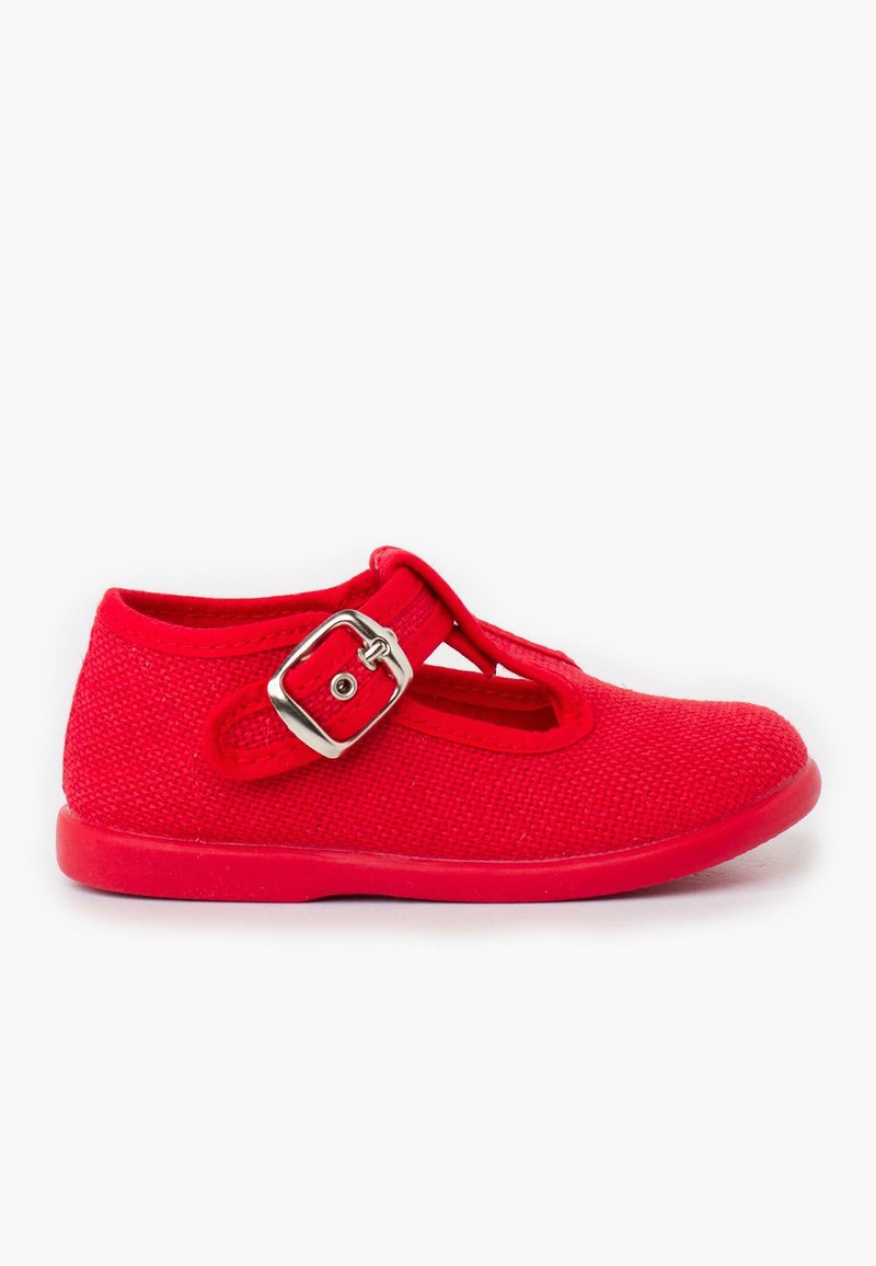 Zapato de charol rojo tipo Mary Jane con parte superior de tela texturizada, hebilla plateada ajustable y suela plana de goma. Presenta un diseño recortado en la parte frontal.