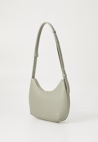 Borsa a spalla in pelle verde con forma curva, chiusura con zip dorata e tracolla regolabile. Texture liscia con un design minimalista.
