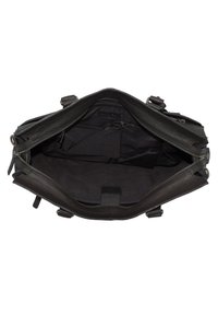 Bolso de cuero negro con un interior espacioso, que presenta una textura suave, un cierre central con cremallera y bolsillos internos para organización.