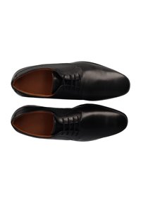 Schwarze Lederdressschuhe mit glatter Oberfläche, runder Zehenpartie, Schnürverschluss und beiger Innenauskleidung. Verfügt über dezente perforierte Akzente.