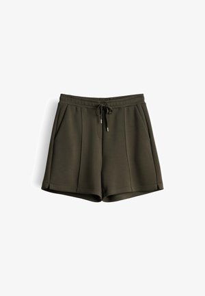 Pantaloncini casual verde scuro con vita elastica, coulisse frontale, tasche laterali e cuciture verticali imbastite su sfondo bianco.