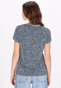 Kortærmet t-shirt i lyseblå med et sort plettet mønster. Har en rund halsudskæring og en afslappet pasform, lavet af blødt stof.