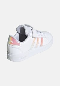 Vit sneakers med överdel i slät syntetisk läder, tre iriserande ränder och en kardborreflik. Gummisula med strukturerat mönster.