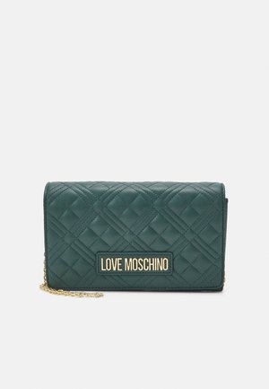 Prošívaná peněženka z umělé kůže zelené barvy s logem ve zlaté barvě a řetězovým popruhem. Má strukturovaný tvar a texturovaný povrch.
