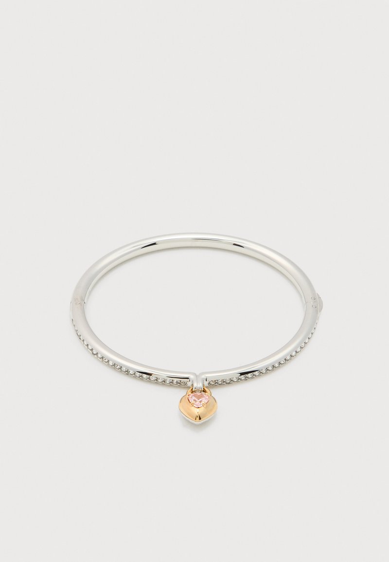 Ασημένιο βραχιόλι με μικρές διάφανες πέτρες στη στεφάνη και χρυσή καρδιά ως γούρι, με ροζ πολύτιμο λίθο στο κέντρο.