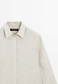 Jasno beżowa koszula w paski, wykonana z bawełny, z długimi rękawami, zapinana na guziki, z klasycznym kołnierzykiem i małą metką z logo przy dekolcie.