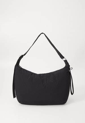 Czarna miękka torba na ramię z tkaniny, z regulowanym paskiem i zamkiem błyskawicznym, prosty design, sfotografowana na białym tle.