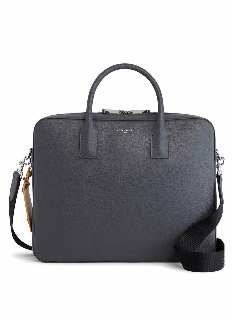 Porte-documents en cuir noir avec poignées arrondies, fermeture éclair argentée et bandoulière noire amovible sur fond blanc.