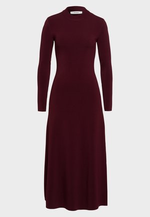 Abito a maniche lunghe e collo alto in un profondo bordeaux. Realizzato in morbido tessuto elasticizzato con una silhouette aderente e gonna fluida.
