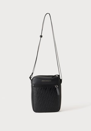 Petit sac bandoulière noir avec sangle réglable, poche zippée à l'avant, motif triangulaire embossé et logo Armani Exchange.