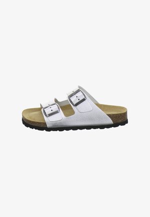 White slip-on sandal with two adjustable silver buckles, light brown footbed, cork midsole, and black textured sole.