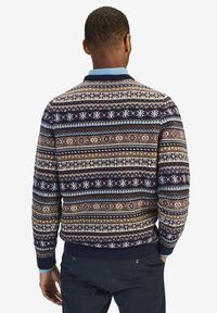 Mörkblå mönstrad tröja med geometriska och snöflinge-designs i beige, brunt och ljusblått. Ribbad mitt och ärmslut; med krage.