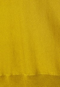 Maglione giallo lavorato a maglia con un motivo testurizzato a coste. Vestibilità liscia, con un orlo che transita verso una maglia più fine nella parte inferiore.