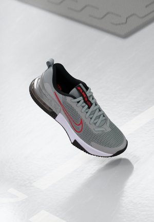 Szaro-czerwony but sportowy Nike Air Max z cholewką z siatki, czarną podszewką, białą podeszwą środkową i widocznym systemem amortyzacji Air Max na jasnym tle podłogi.