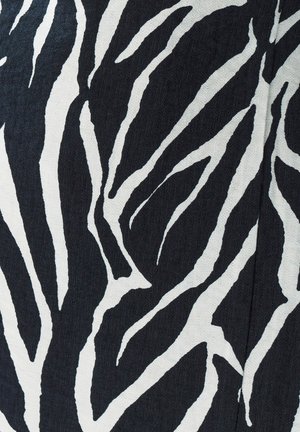 Tessuto a strisce con motivo zebra, caratterizzato da bold strisce bianche e nere, con una superficie testurizzata che aggiunge profondità al design.