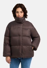 Veste matelassée marron avec col haut, design matelassé et poignets élastiques. Détails de logo sur la poitrine et ourlet à cordon de serrage.