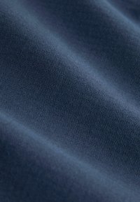 Navy blue fabric with a subtle textured pattern, featuring a smooth surface and gentle drape, highlighting the material's soft quality.