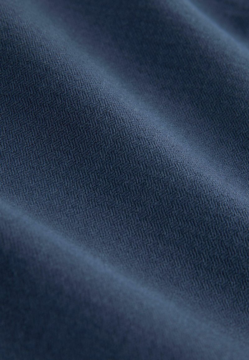 Navy blue fabric with a subtle textured pattern, featuring a smooth surface and gentle drape, highlighting the material's soft quality.
