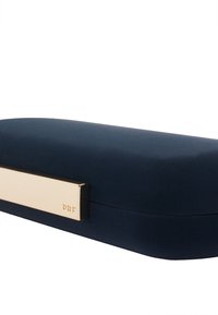 Étui à lunettes bleu marine avec une surface à texture lisse, doté d'une fermeture accentuée d'or et d'un détail gravé "PRF" sur le côté.