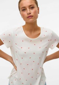 Hvid kortærmet t-shirt med rund halsudskæring, prydet med spredte røde vandmelonfrø-mønstre over det hele. Letvægtsstof og afslappet pasform.