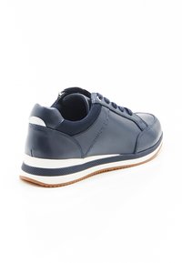 Marineblauwe sneaker met een glad leren buitenkant, witte tussenzool, gestructureerde rubberen zool en bijpassende veters. Bevat een gevoerde kraag en tong.