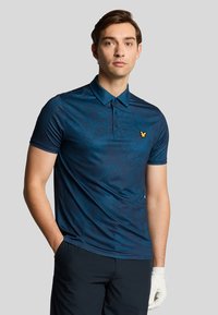 Polo a maniche corte di colore verde scuro con un delicato motivo testurizzato; presenta un colletto e un piccolo logo dorato sul petto.