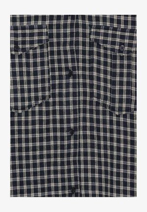 Námořnická a bílá kostkovaná flanelová košile s dvěma náprsními kapsami, zapínáním na knoflíky a černými knoflíky, která předvádí měkkou, texturovanou látku.