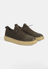Bruine leren sneakers met een stevige, ronde neus, meertextuur bovenmateriaal en rubberen tan zool. Voorzien van vetersluiting met contrasterende stiksels.