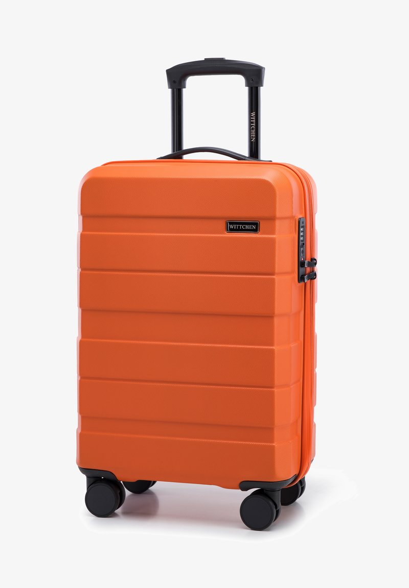 Valise rigide orange avec une texture rainurée, deux roues noires, et une poignée télescopique. Équipée d'un cadenas à combinaison et d'un logo de marque.