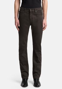 Dunkelbraune Jeans mit geradem Schnitt, aus Denim gefertigt. Verfügt über fünf Taschen, einen Knopfverschluss und dezente Ziernähte. Schwarze Stiefel sind sichtbar.