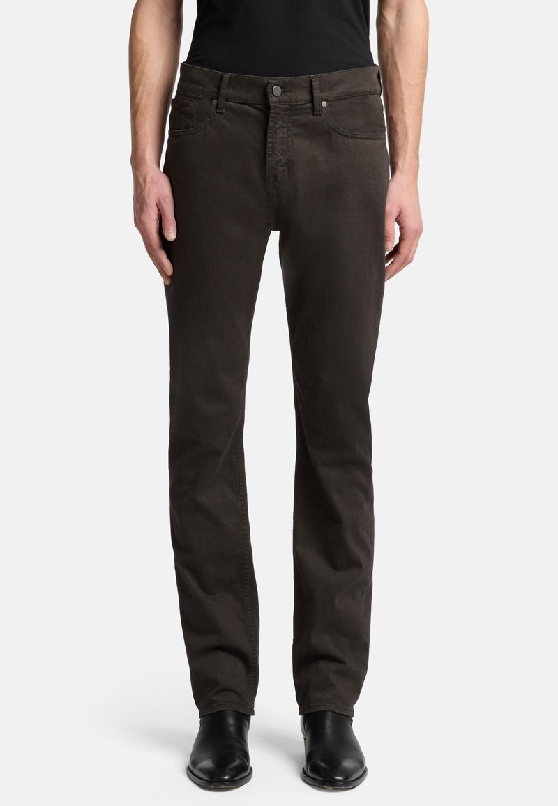 Dunkelbraune Jeans mit geradem Schnitt, aus Denim gefertigt. Verfügt über fünf Taschen, einen Knopfverschluss und dezente Ziernähte. Schwarze Stiefel sind sichtbar.