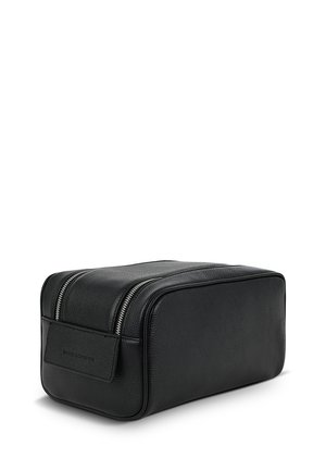 Czarna skórzana kosmetyczka o prostokątnym kształcie, teksturowanej powierzchni, z podwójnymi suwakami na górze oraz małą przednią kieszonką bez widocznego logo.