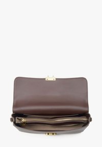 Hnědá kožená kabelka se zlatým zapínáním, vybavená prostorným interiérem a kapsou na zip. Hladký povrch, obdélníkový tvar.