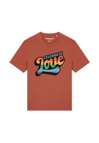 T-shirt en coton orange rouille avec un grand motif textuel multicolore qui indique "CÉLÉBRER l'Amour" dans un design ludique.