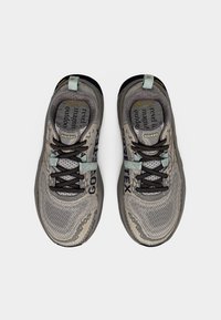 Γκρι υπαίθρια αθλητικά παπούτσια με πλέγμα στην επάνω πλευρά, επωνυμία GORE-TEX, μαύρα κορδόνια και υφή από καουτσούκ στις σόλες. Διαθέτουν ανοιχτό μπλε ταμπόν στη φτέρνα.